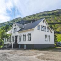 a white house with a hill in the background at Hotel Aldan - The Bank, Seyðisfjörður