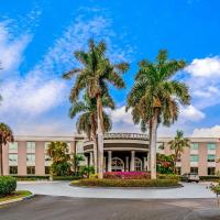 a building with palm trees in front of it at La Quinta by Wyndham Naples Downtown