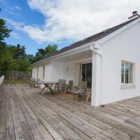 a white house on a wooden deck at Brittas Bay Park No 12 by Trident Holiday Homes