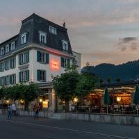 a building on a street with people walking down the street at Hotel Krebs Interlaken