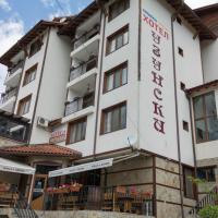 a large white building with tables and chairs in front of it at Hotel Uzunski, Smolyan