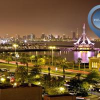 a view of a city at night with the malaysia sign at ibis Kuwait Salmiya