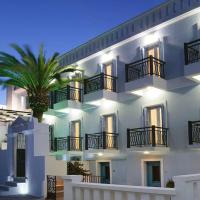a white building with a palm tree in front of it at Virginia Hotel, Tinos