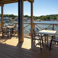 a deck with tables and chairs on the water at Fisherman's Wharf Inn, Boothbay Harbor