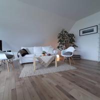a white living room with a white couch and chairs at Ferienwohnung am Kellersee, Eutin