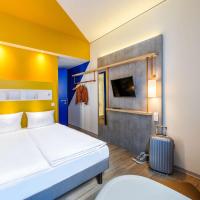a hotel room with a bed and a suitcase at ibis budget Bremen City Center