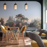 a restaurant with chairs and a table and a mural at Grand Hôtel Bristol, Colmar