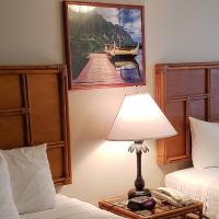 a hotel room with two beds and a lamp at Imperial Hawaii Resort, Honolulu