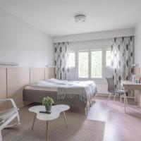 a bedroom with a bed and a table and chairs at Hotel Kuntosumppu, Rauma