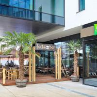 a restaurant with palm trees in front of a building at ibis Styles Liege Guillemins, Liège