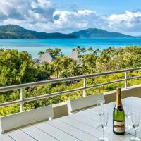 a bottle of wine sitting on a table with wine glasses at Beach Lodges, Hamilton Island