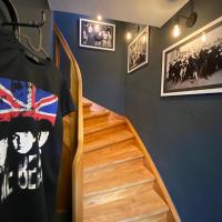 a room with a staircase and a t shirt on the wall at Planet Gast - Beatles-Wohnung, Marklohe