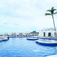 a large swimming pool with chairs and palm trees at The Inn at Mazatlan, Mazatlán