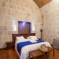 a bedroom with a large bed in a stone wall at Hotel Casona Solar, Arequipa