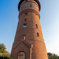 a brick lighthouse with a door in front of it at Apart Hotel Wasserturm, Bad Segeberg