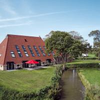 a building with a red roof next to a river at Farm house Van der Valk Hotel Leeuwarden