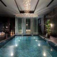 a swimming pool in a hotel with a chandelier at Lure Hotel & Spa - Adults Only, Mellieħa