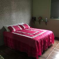 a bedroom with a bed with a pink blanket on it at Casa da waldir quarto suíte 01, Goiás