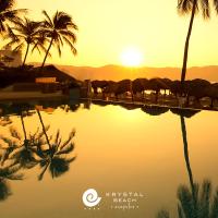 a pool of water with palm trees and the sunset at Krystal Beach Acapulco