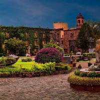 a large building with a garden in front of it at Posada de la Aldea, San Miguel de Allende