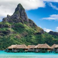 a mountain with a row of huts in the water at InterContinental Bora Bora & Thalasso Spa, an IHG Hotel