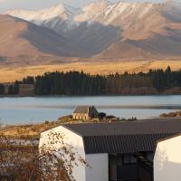a house with a view of a lake and mountains at The Godley Hotel, Lake Tekapo