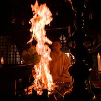 a man is sitting in front of a fire at Koyasan Syukubo Ekoin Temple
