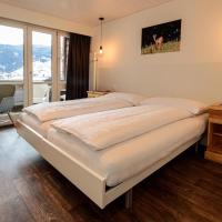 a bedroom with a large bed with a desk and a chair at Jungfrau Lodge, Swiss Mountain Hotel, Grindelwald
