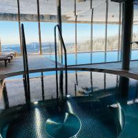 a hot tub in a building with a view of the mountains at Hotel Tetřeví Boudy, Pec pod Sněžkou