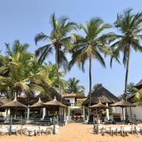 a resort on the beach with palm trees at Boblin la Mer hotel restaurant plage, Grand-Bassam