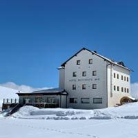 a white building in the snow with snow covered ground at Hotel Col di Lana, Canazei