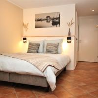 a bedroom with a bed and a tiled floor at Wadden (W)eiland Bed en Breakfast op Texel, Oudeschild