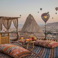 a balcony with couches and a table and hot air balloons at Divan Cave House, Göreme
