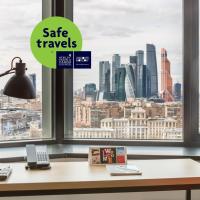 a desk with a lamp and a view of a city at AZIMUT Hotel Smolenskaya Moscow