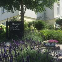a garden with purple flowers and a sign in front of a building at Quartier 29, Eutin