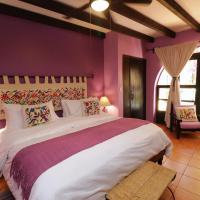 a bedroom with a large bed with purple walls at Casa Mia Suites, San Miguel de Allende