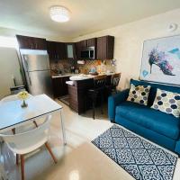 a living room with a blue couch and a kitchen at Remodeled apt with patio and laundry. Pet friendly, Ponce