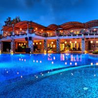 a large building with a large swimming pool at night at The Marmara Bodrum - Adult Only, Bodrum City