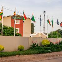 a fence with flags in front of a house at Stay Afrique Hotel, Bulawayo
