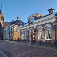 a cobblestone street with buildings and a church at hotel 't Doktershus, Lemmer