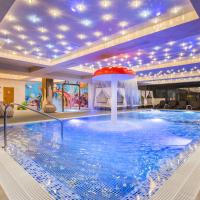 a large swimming pool with a fountain in a building at Park & Spa Hotel Markovo, Plovdiv