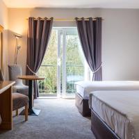 a hotel room with two beds and a television at The Lodge at Woodenbridge, Arklow
