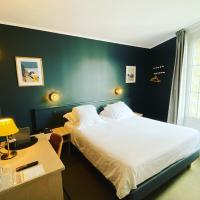 a bedroom with a bed and a desk with a night stand at Hotel du Parc, Dinard