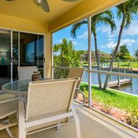 a balcony with a table and chairs and a view of the water at Coconuts & Coladas 2, Cape Coral