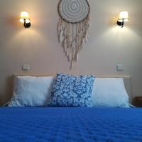 a bedroom with a blue bed with two lights on the wall at Quartos Abelha, Porto Covo