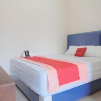 a bed with a blue and red blanket on it at RedDoorz Syariah near Gatot Subroto Lampung 4