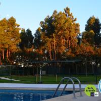 a swimming pool with a canopy and trees in the background at Valbom by Campigir, Sesimbra