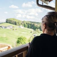 a woman looking out a window at a green field at Kollerwirt, Kapfenstein