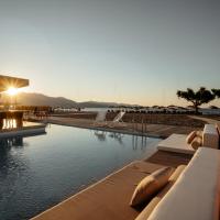 a swimming pool with the sun setting over the water at Enorme Teatro Beach, Amoudara Herakliou