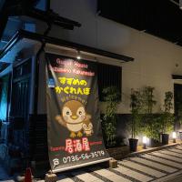 a banner on the side of a building at night at Guest House Suzumeno Kakurembo, Koyasan